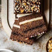 Two slices of filled gingerbread cake on a tan platter.