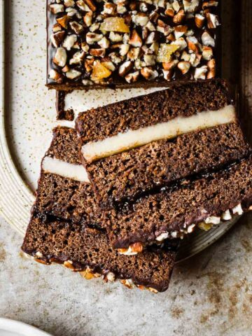 Two slices of filled gingerbread cake on a tan platter.