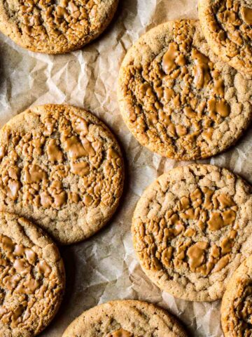 Round butter cookies on brown parchment paper.