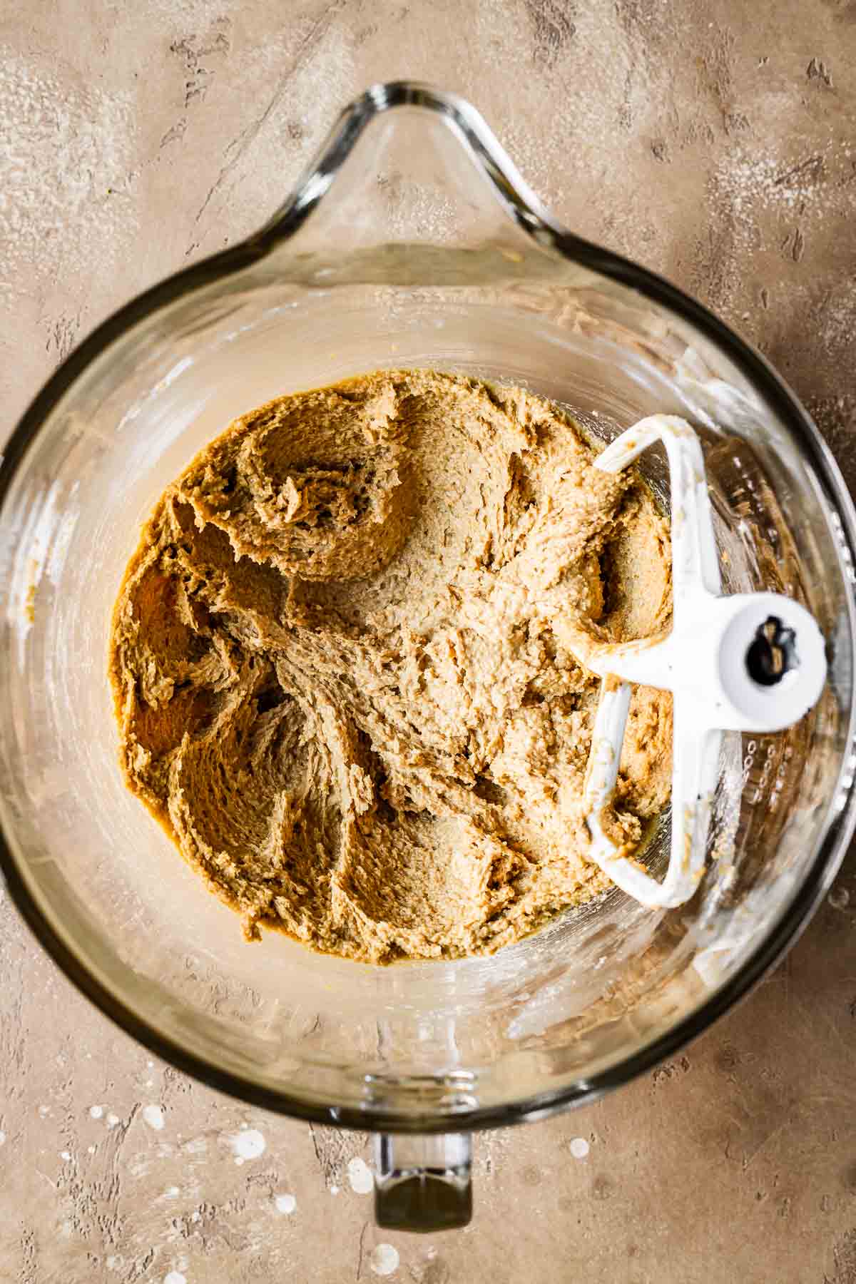 A mixing bowl with creamed butter and sugar for cookie dough.