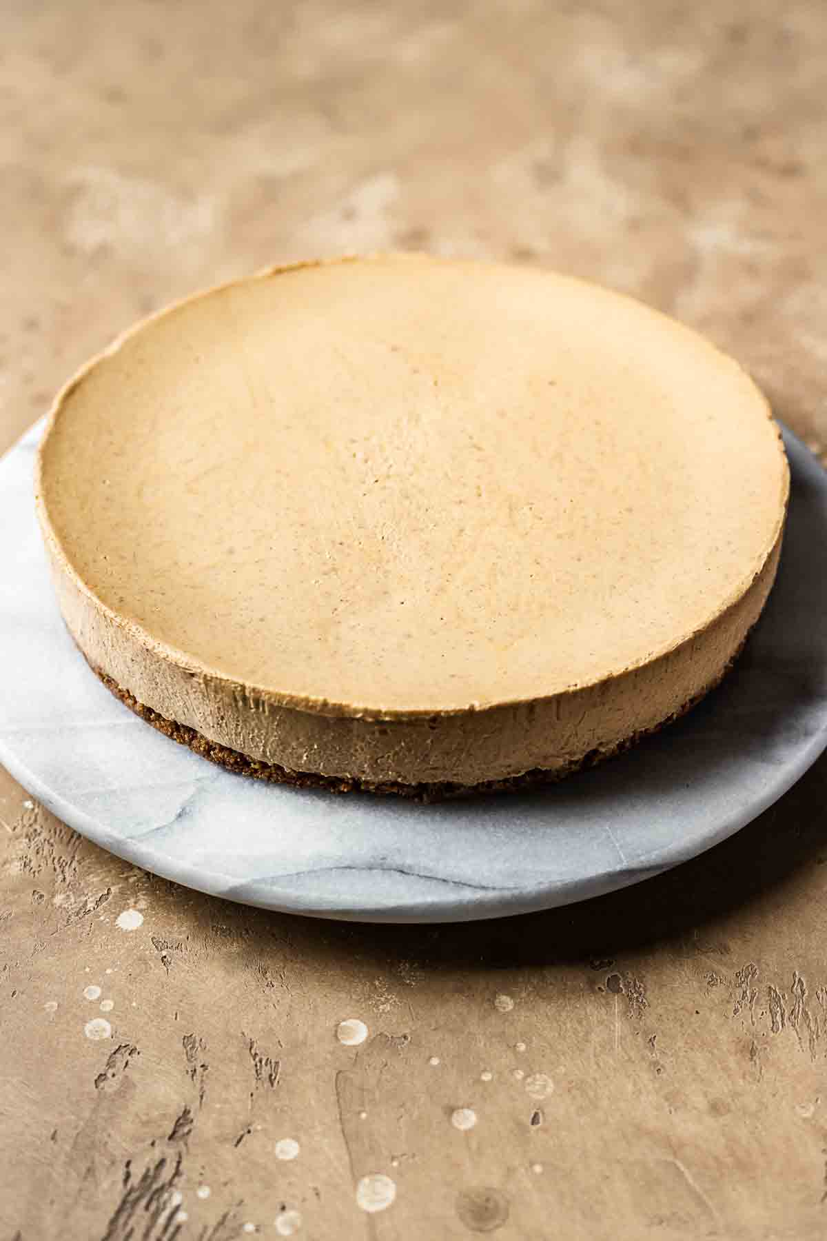 Baked gingerbread cheesecake on a grey marble platter.