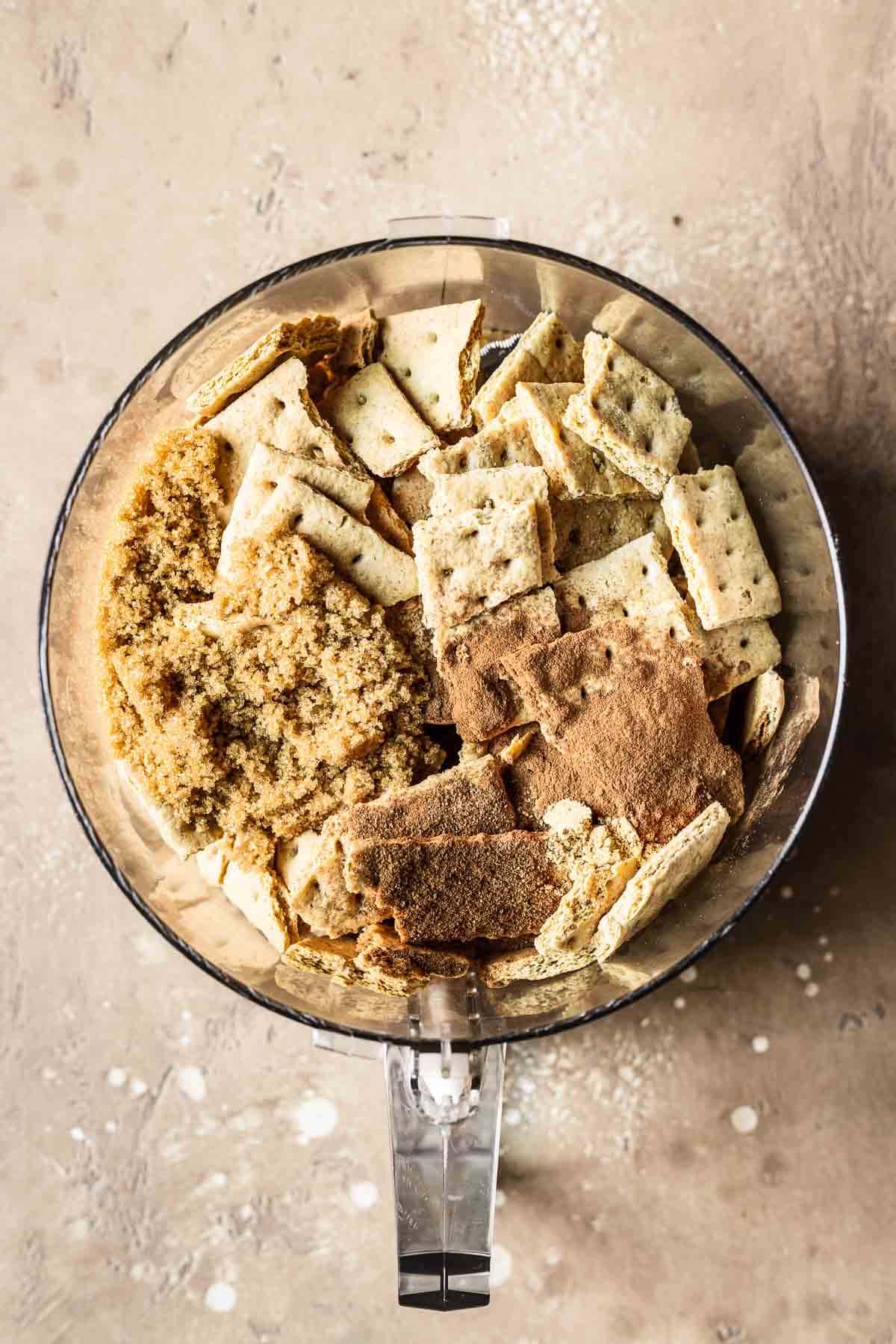 Spiced graham cracker crust ingredients in food processor.