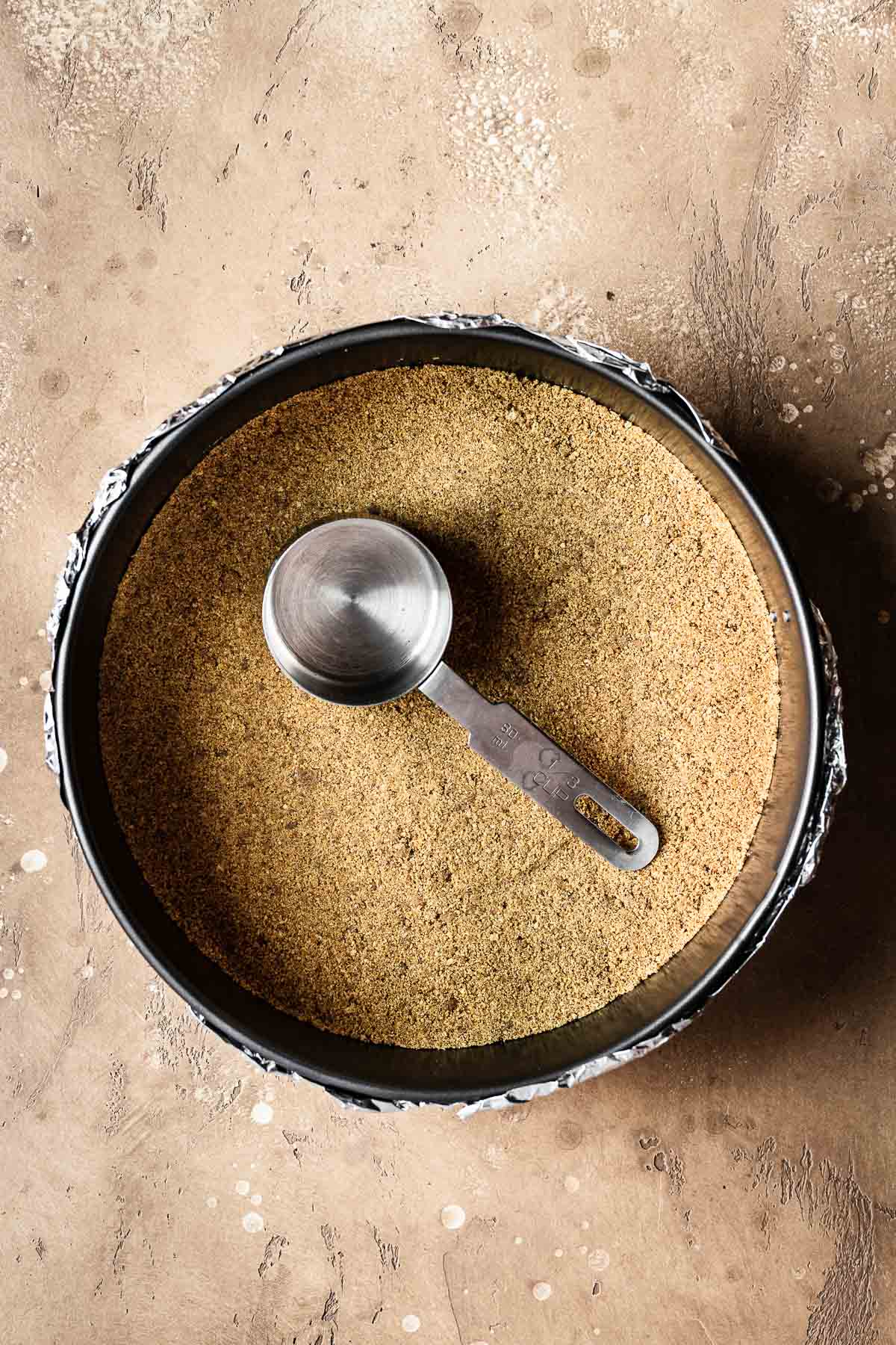 A spiced graham cracker crust pressed into a springform pan.