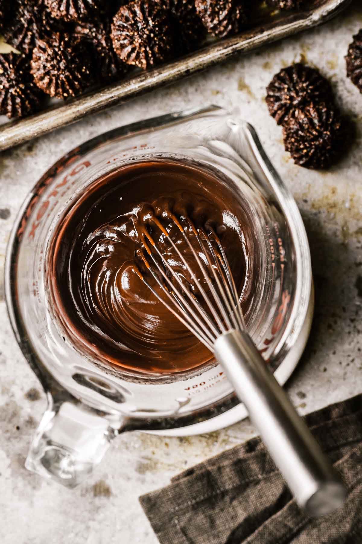 Chocolate ganache smoothly whisked in a glass measuring cup.