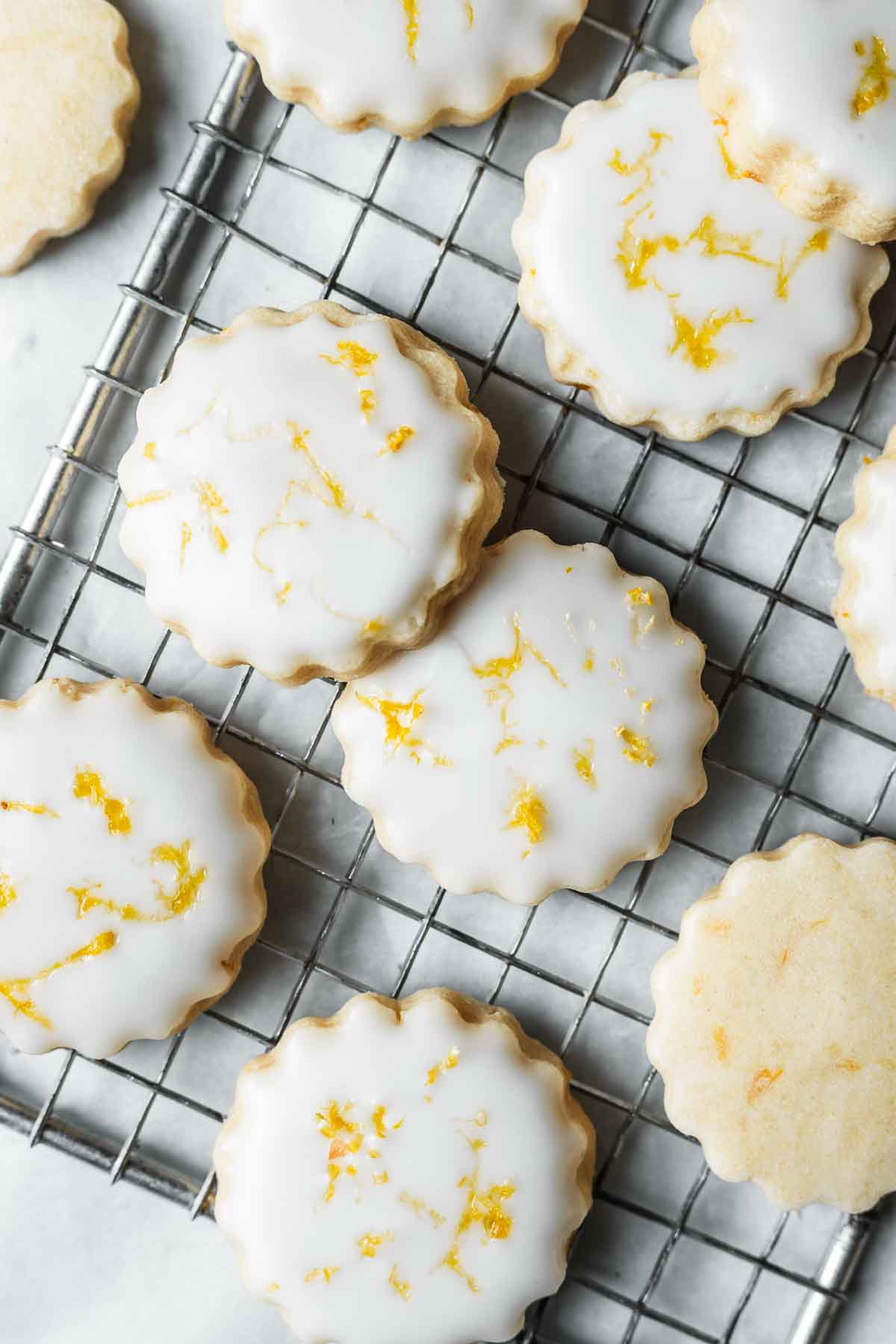 Glazed lemon shortbread cookies with lemon zest.