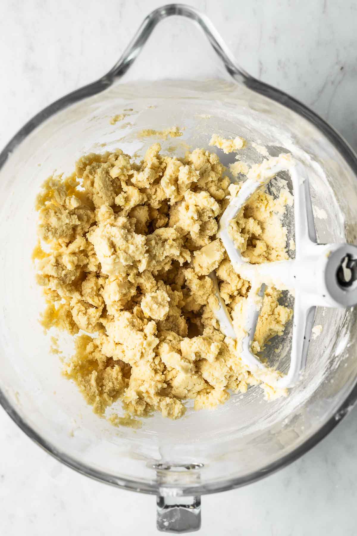 Dough for shortbread cookies in a clear glass mixing bowl.