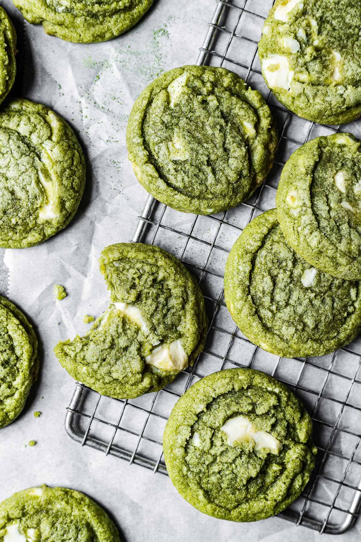 Matcha cookies on a metal wire cooling rack and white parchment paper.
