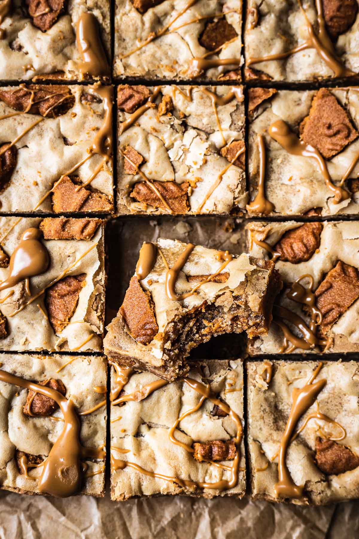 A pan of sliced blondies with one square turned on an angle to show the chewy center.