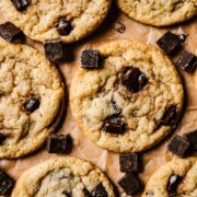 A close up image of egg free chocolate chip cookies on brown parchment paper.