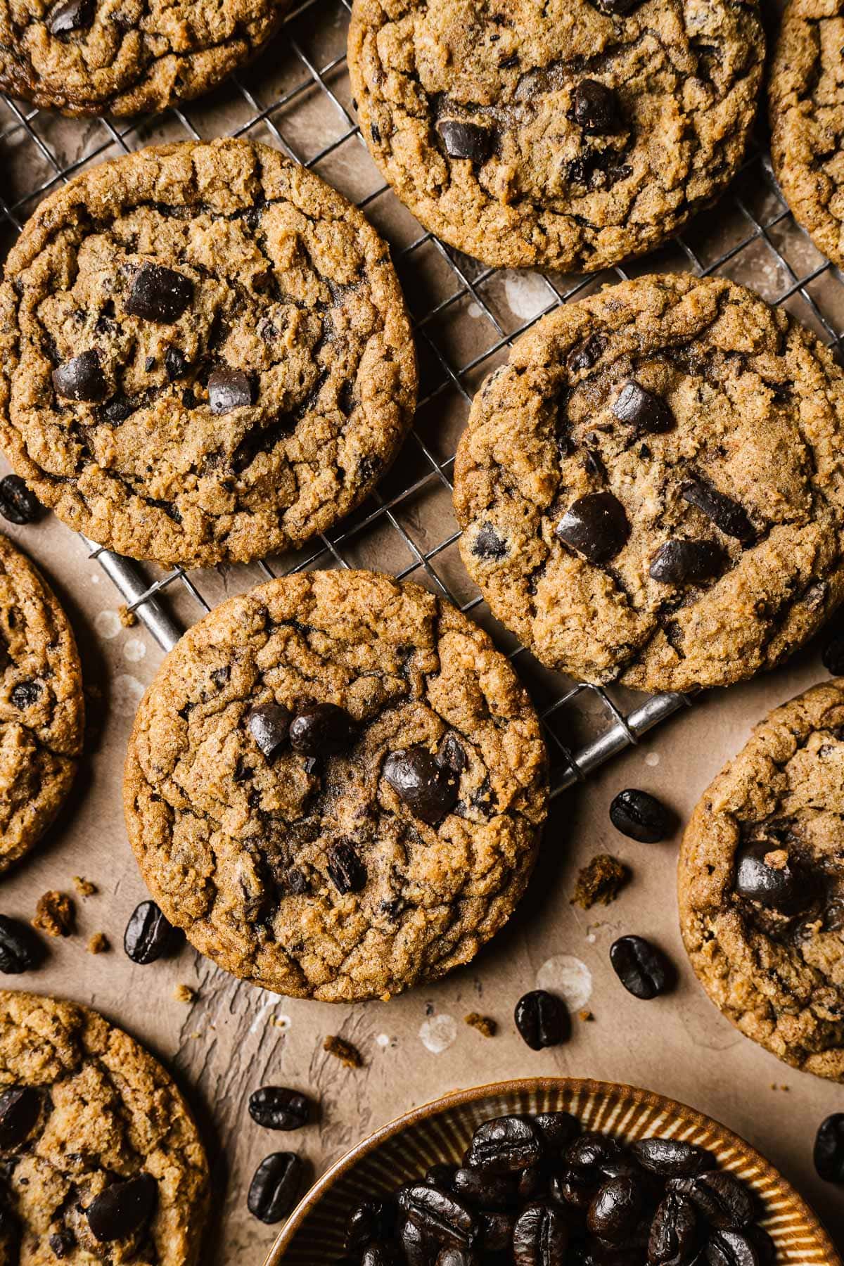 Cookies with instant coffee and chopped chocolate covered coffee beans on a metal cooling rack.