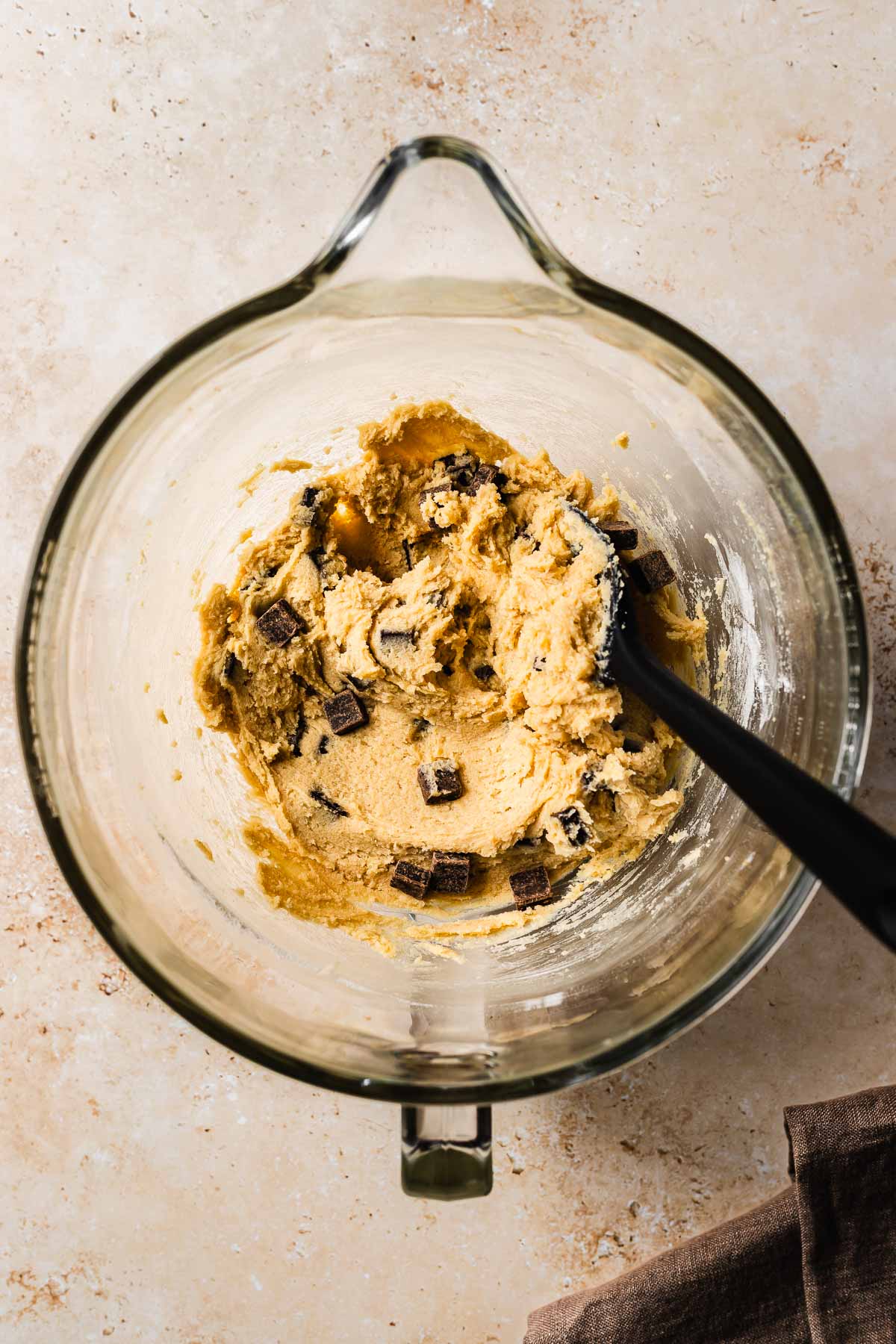 Finished eggless chocolate chip cookie dough in a glass mixing bowl.