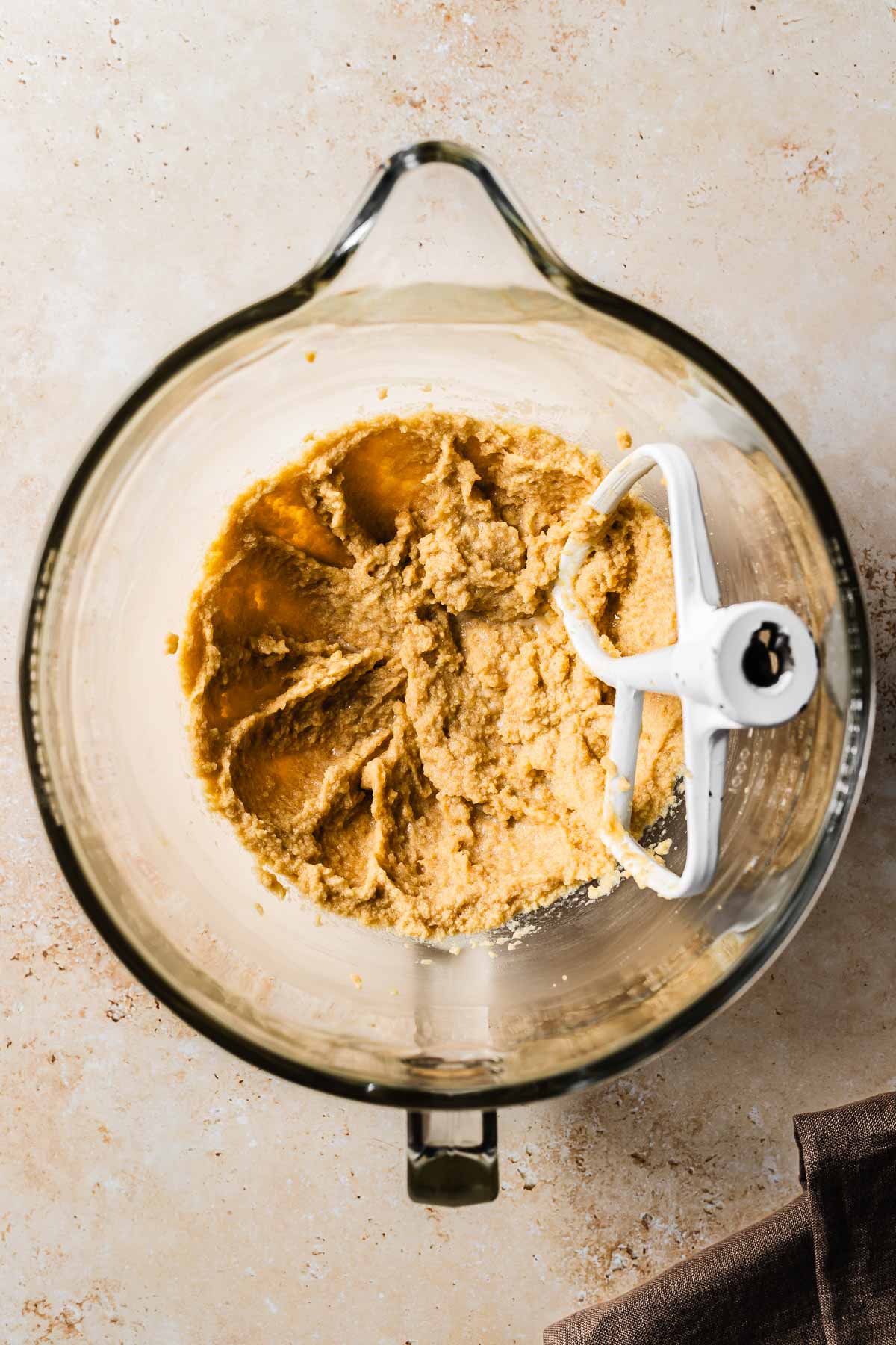 Vanilla and egg substitute added to butter and sugar in a glass mixing bowl.