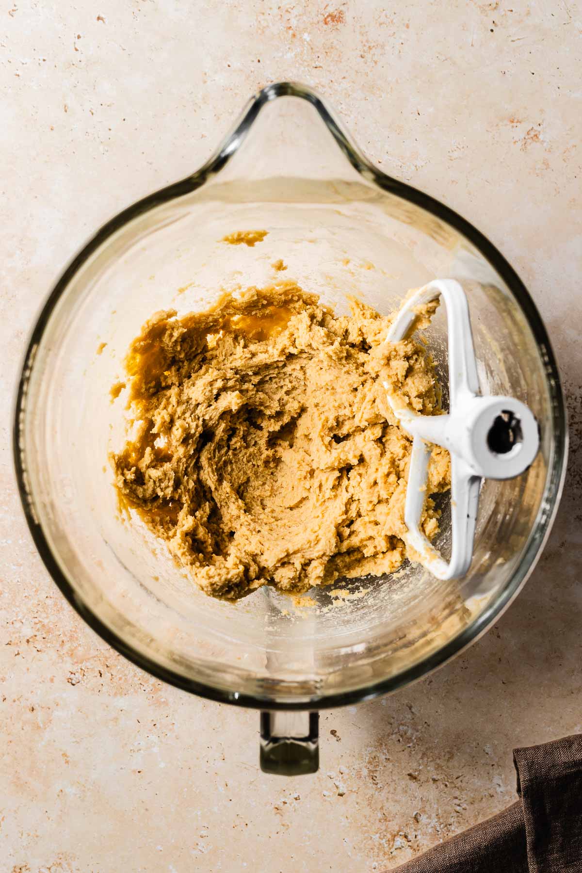 Cookie dough in a glass mixing bowl, before adding chocolate chips.