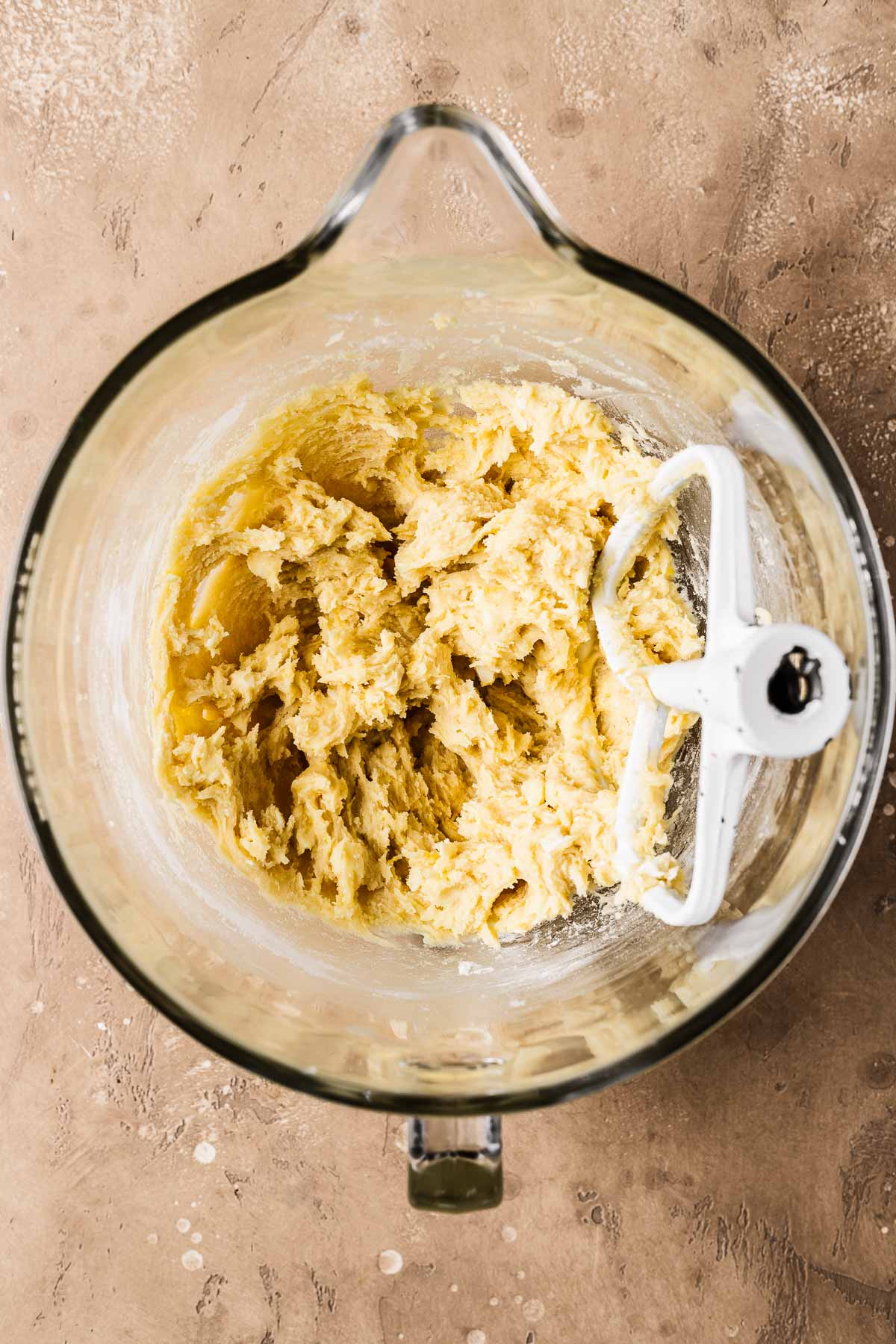 A clear glass mixing bowl filled with cookie dough.