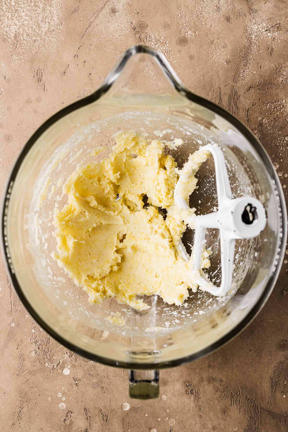 A mixing bowl with creamed butter and sugar.
