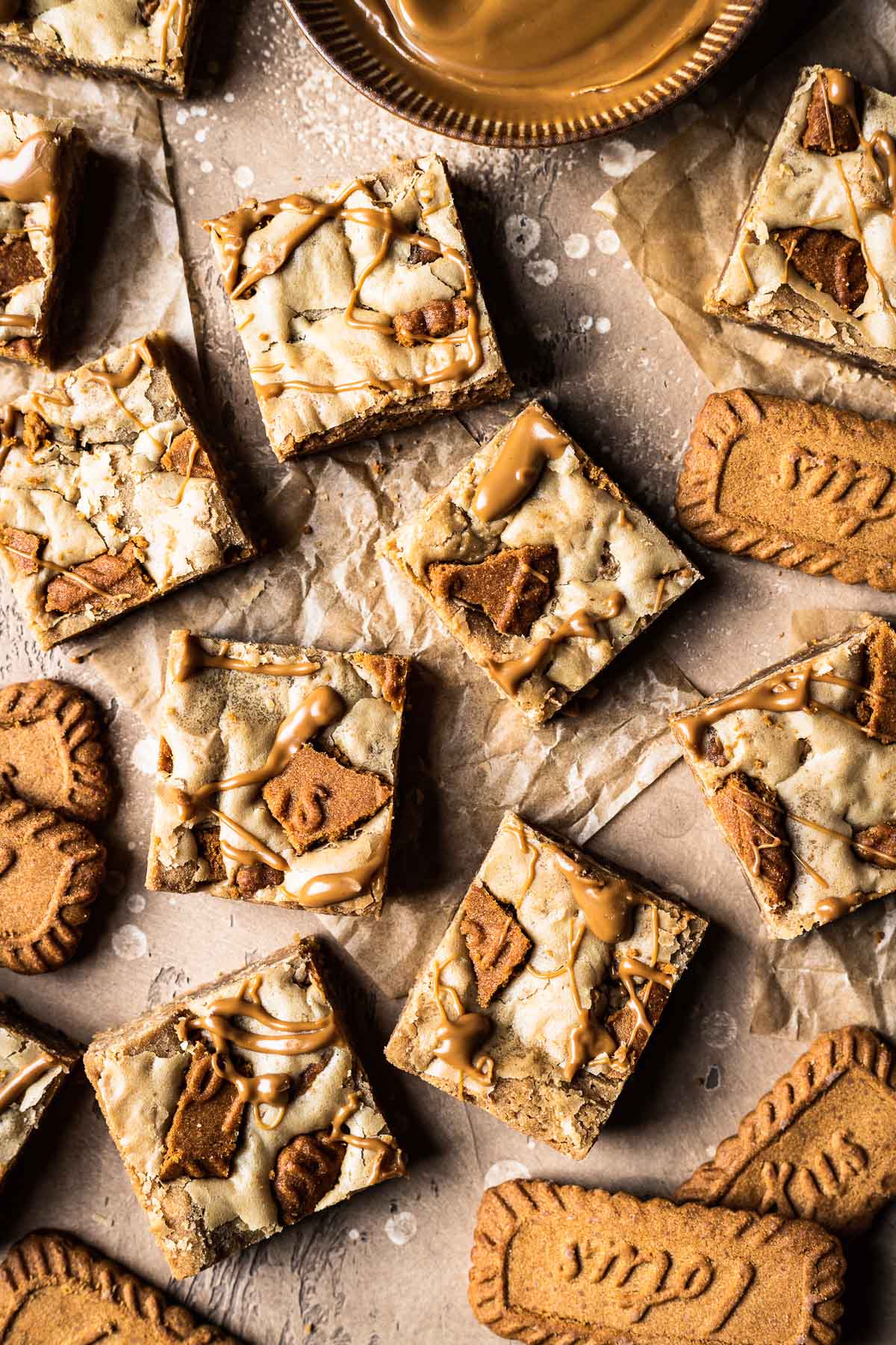 Lotus biscoff blondie squares on brown parchment paper.