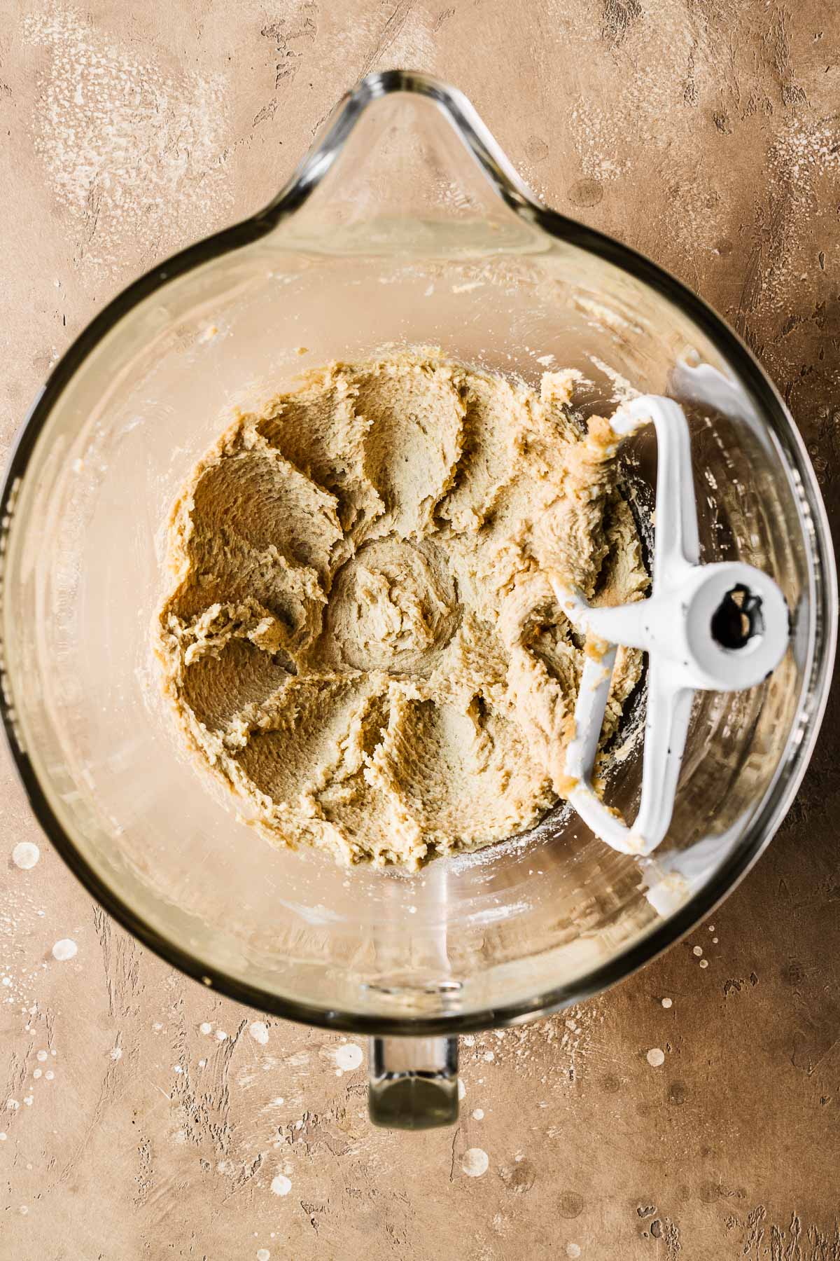 Creamed butter and sugar in a clear glass mixing bowl.