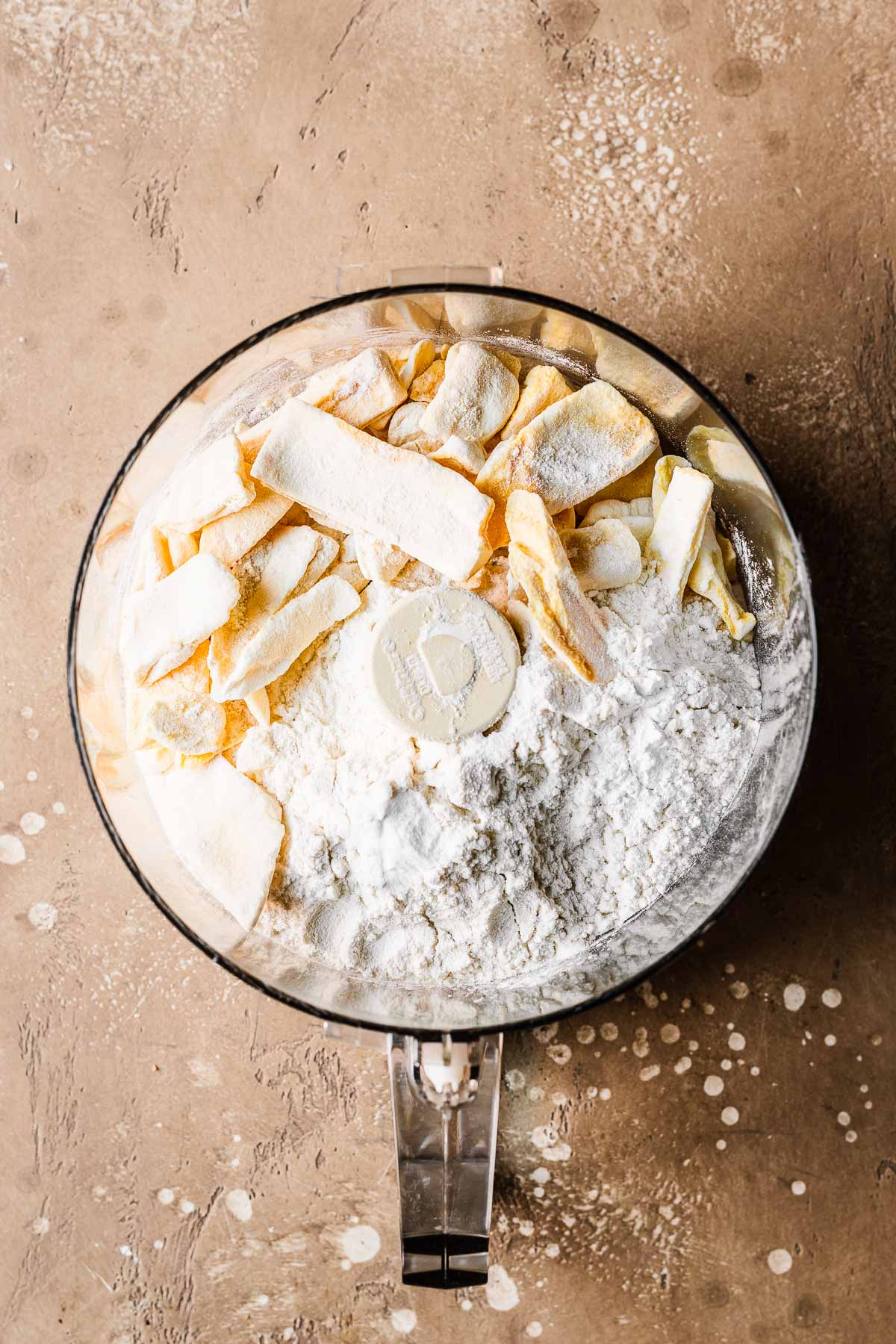 Freeze dried mangos, flour and leaveners before processing in a food processor bowl.