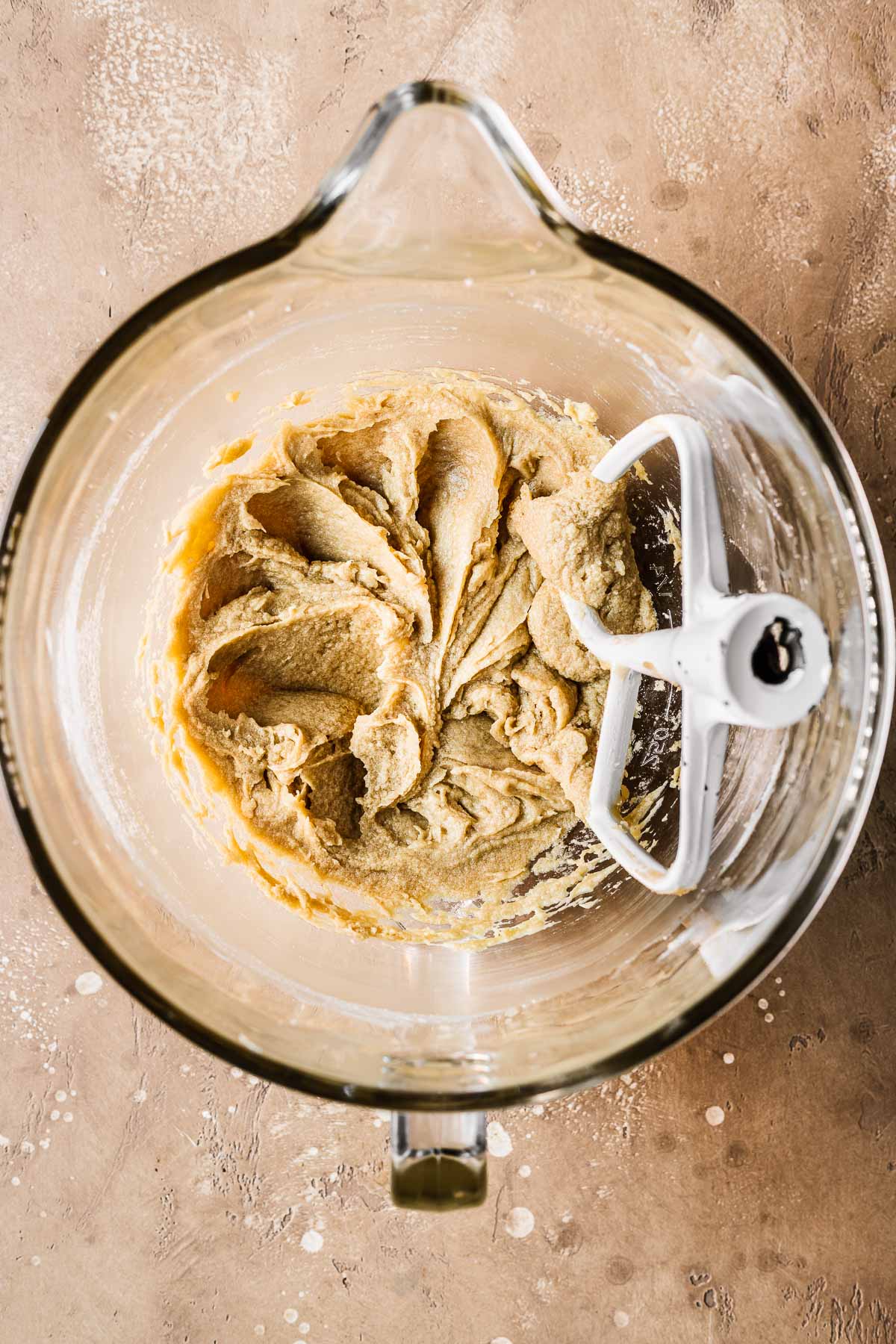 Butter, sugar and eggs mixed together in a clear glass bowl.