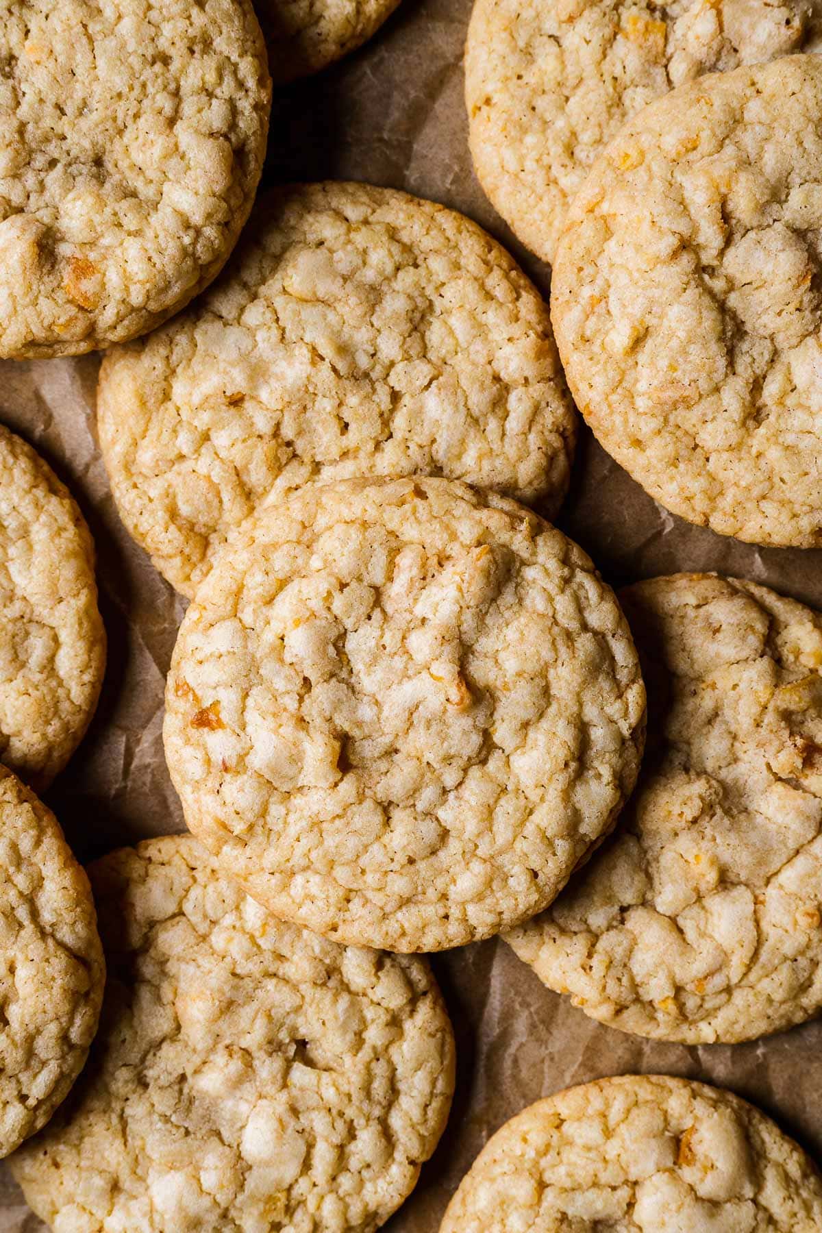 Golden brown cookies piled on brown parchment paper.