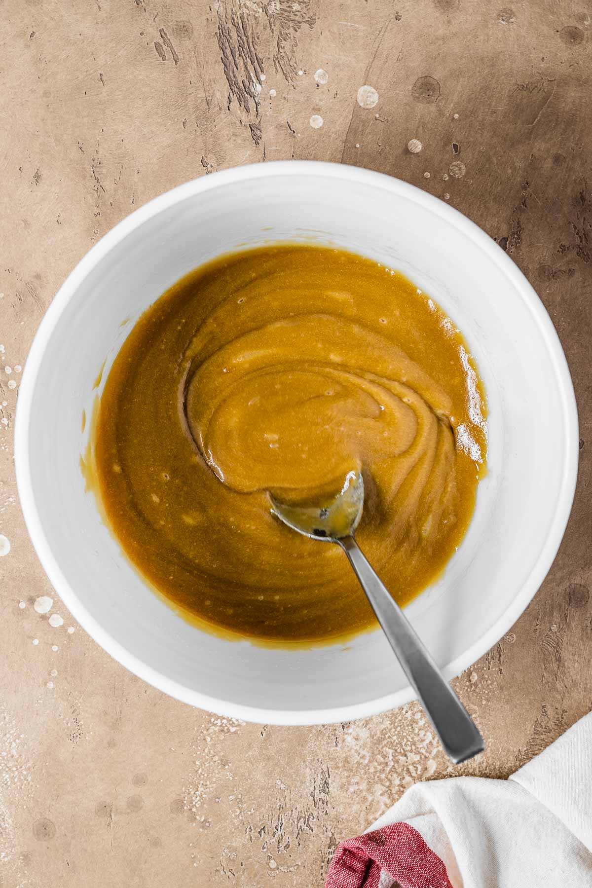 Melted butter, sugar and white chocolate in a mixing bowl.