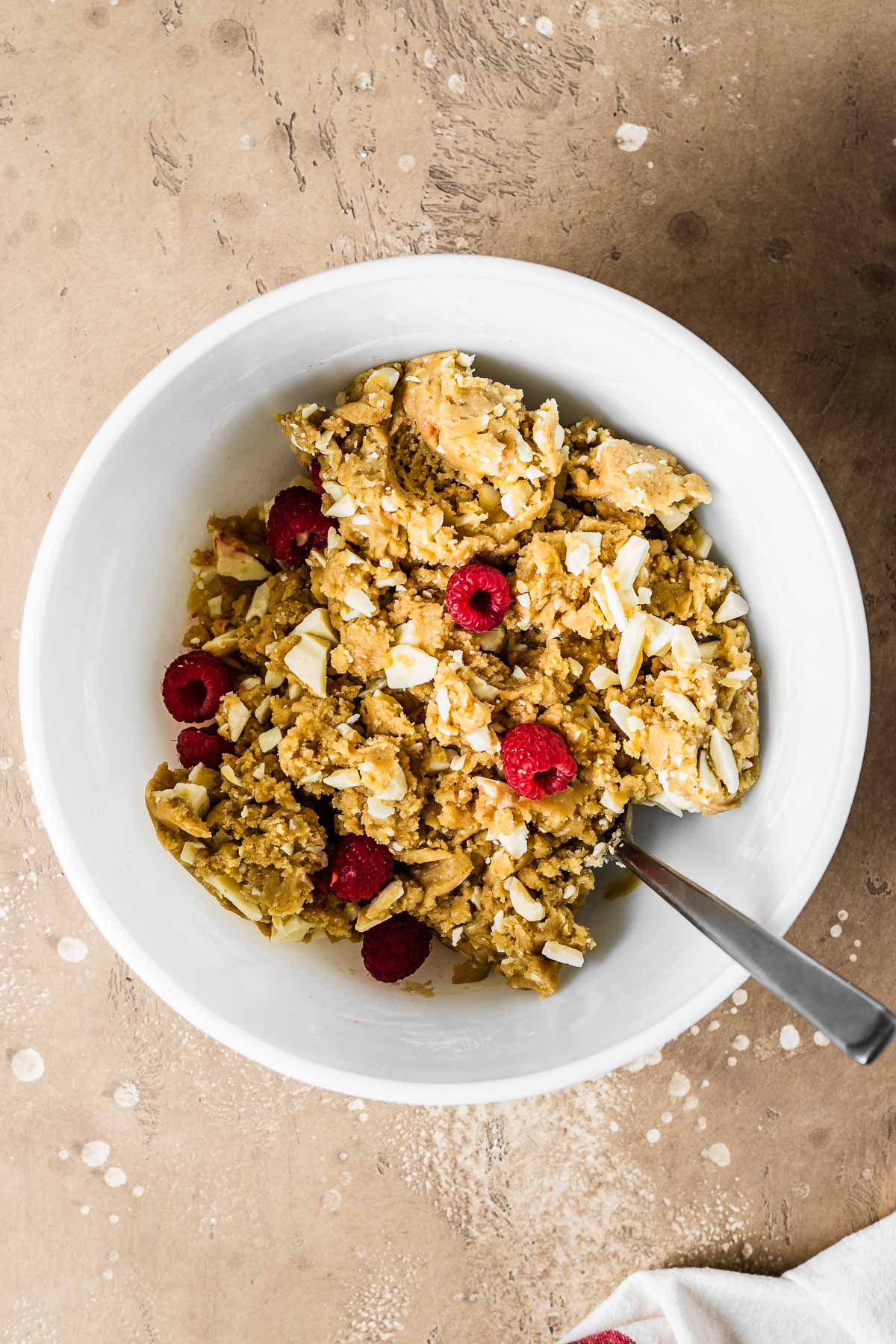 Raspberry and white chocolate blondie dough in a mixing bowl.