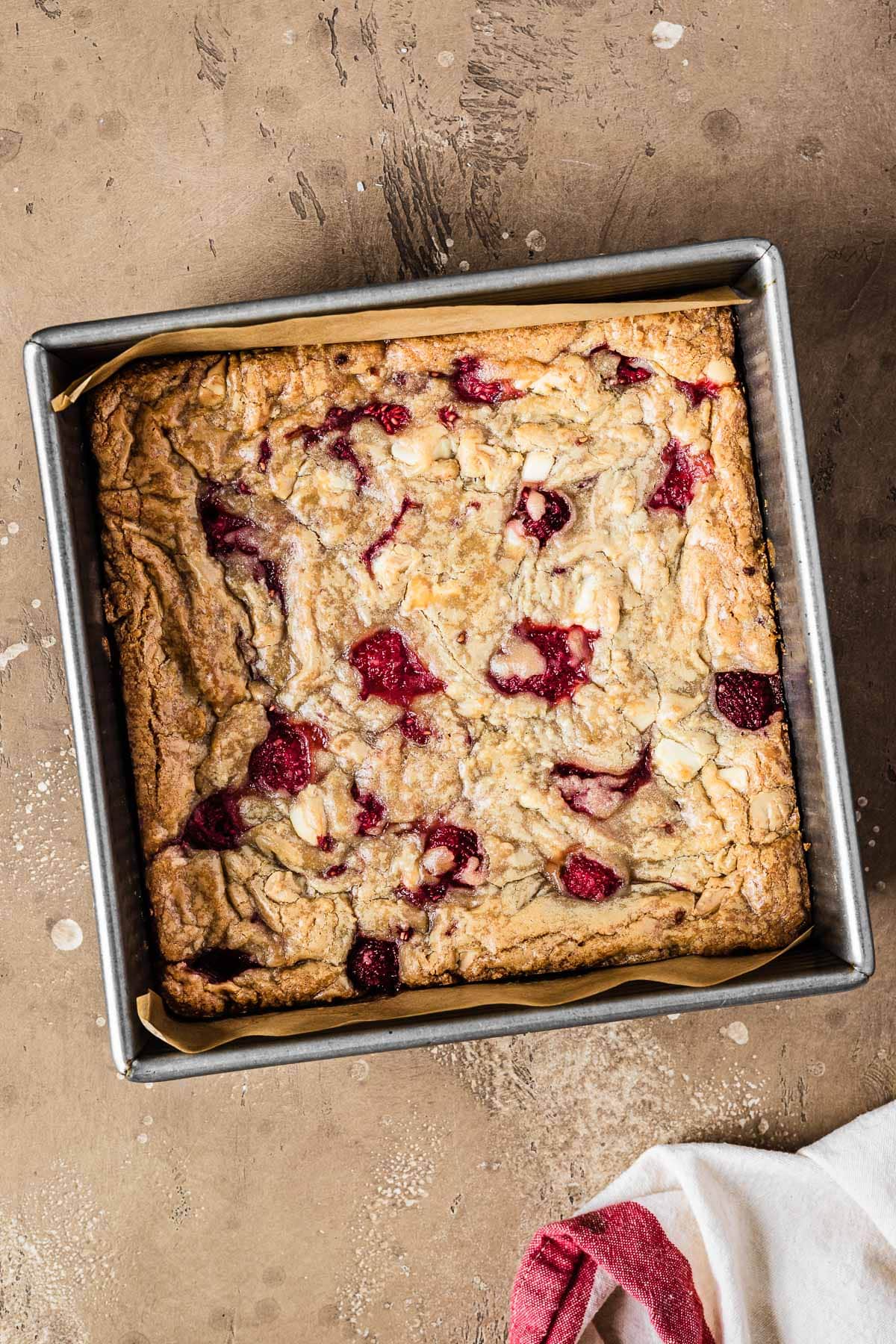 A square pan of baked rasberry blondies that have not yet been cut.