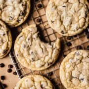 Chocolate chip cookies on a wire cooling rack with one bite taken out of a cookie.