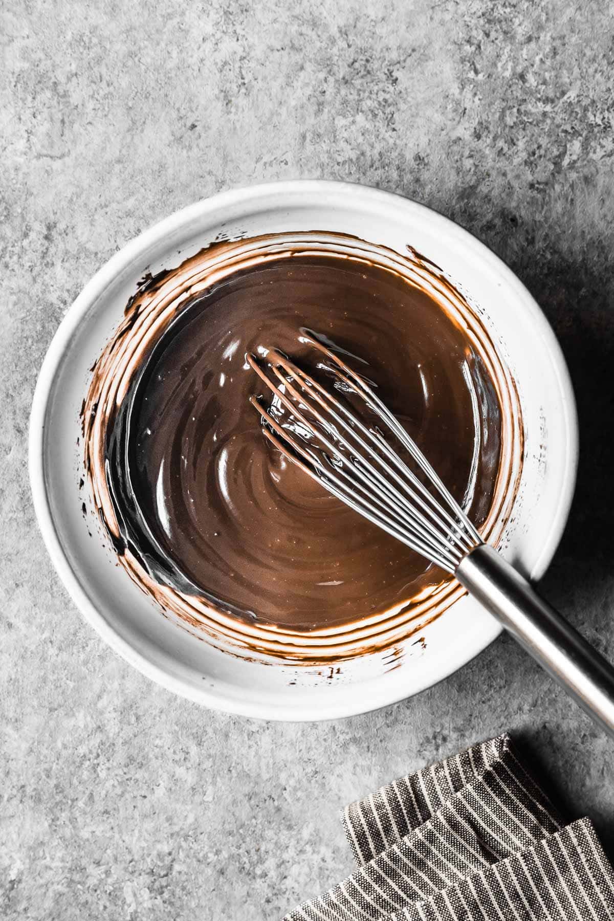 A white ceramic bowl of chocolate ganache.