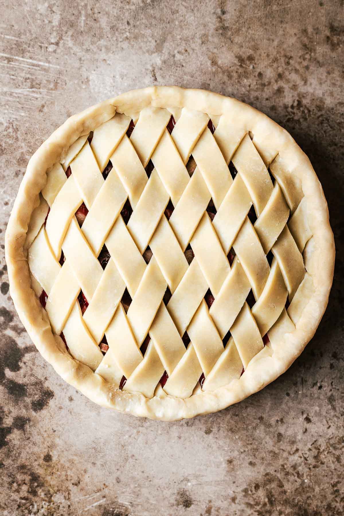 A diamond lattice topped pie with the overhanging bottom crust folded in and over the lattice ends.