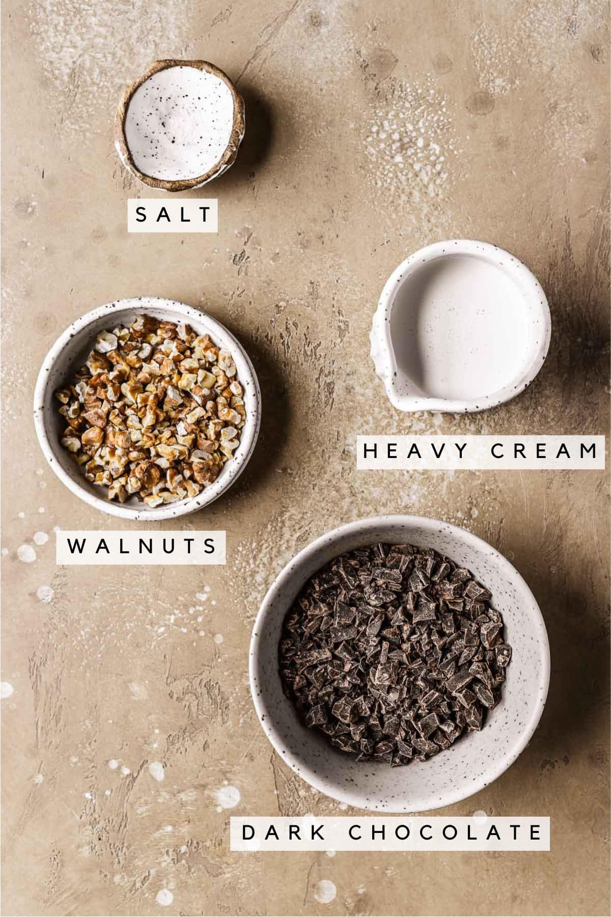 Labeled ingredients in bowls for whipped chocolate ganache and cake topping.