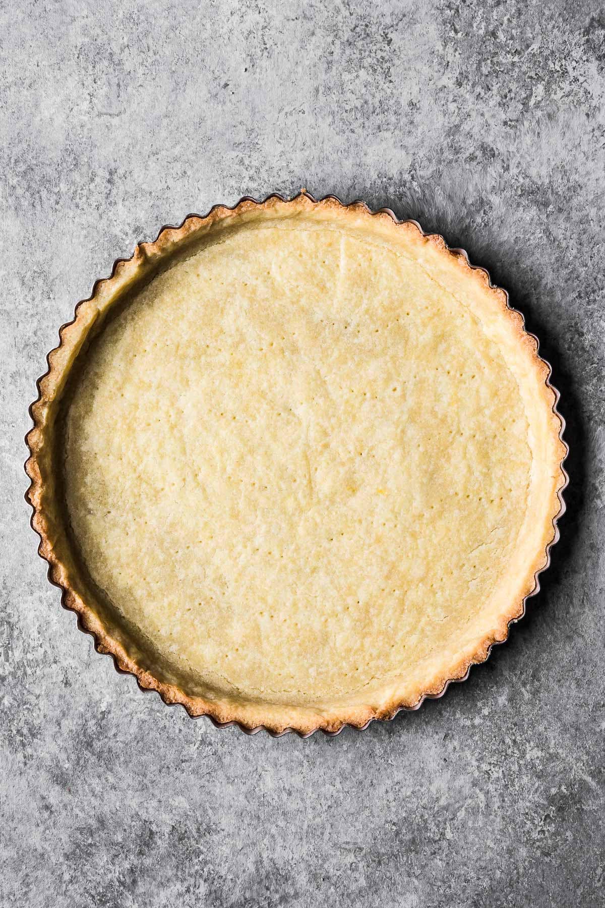 Parbaked pate sucree dough in a round tart pan.