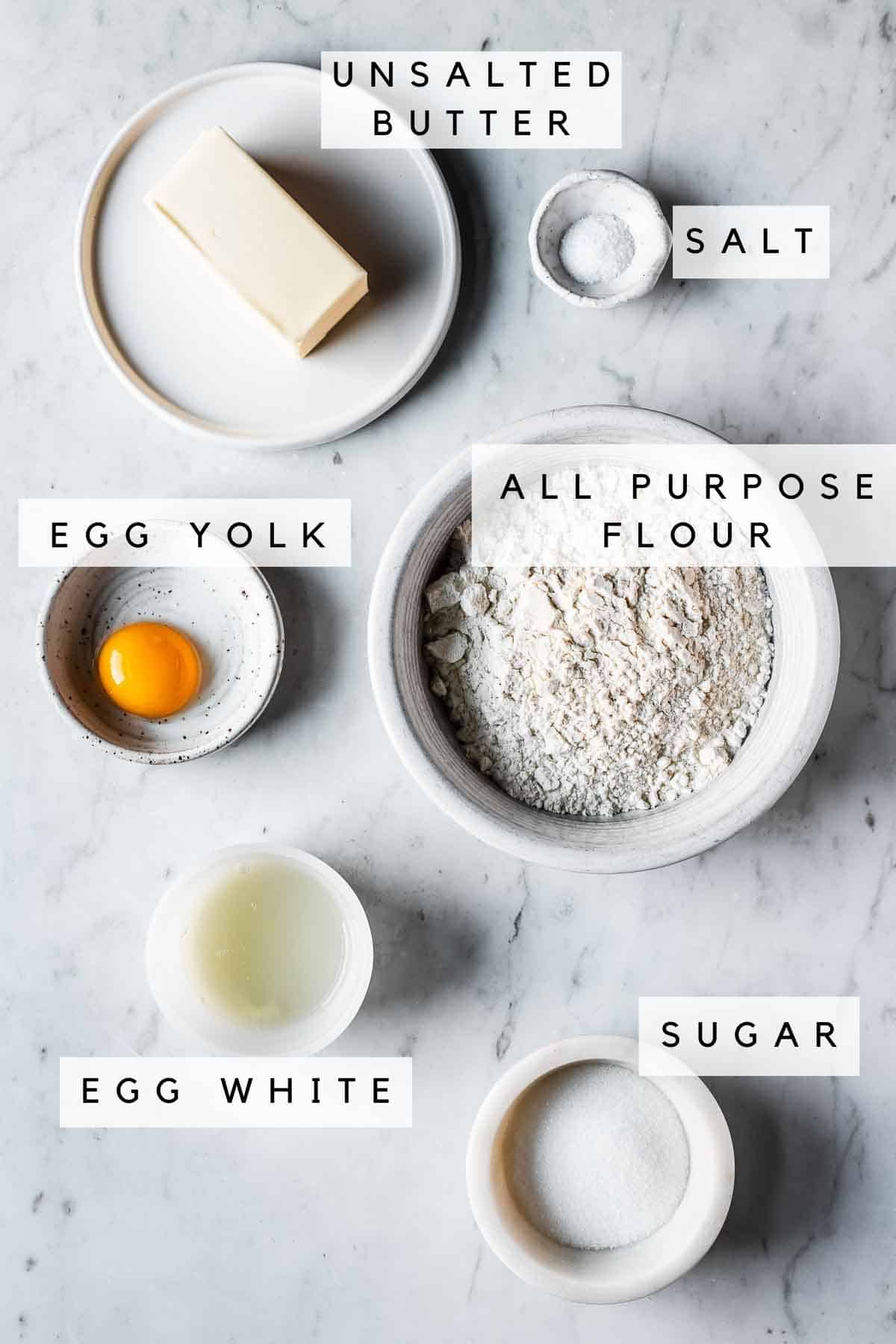 Labeled ingredients in bowls for pate sucree recipe.