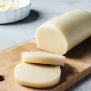 A log of almond paste with two slices cut nearby.