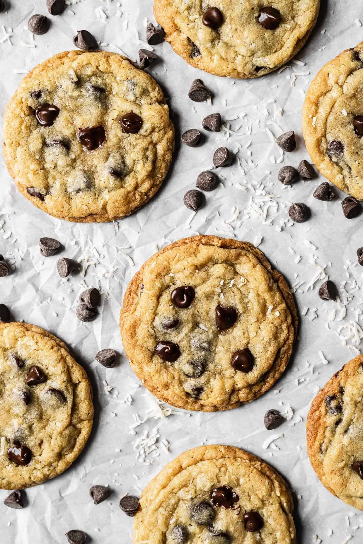 Coconut chocolate chip cookies on white parchment paper.