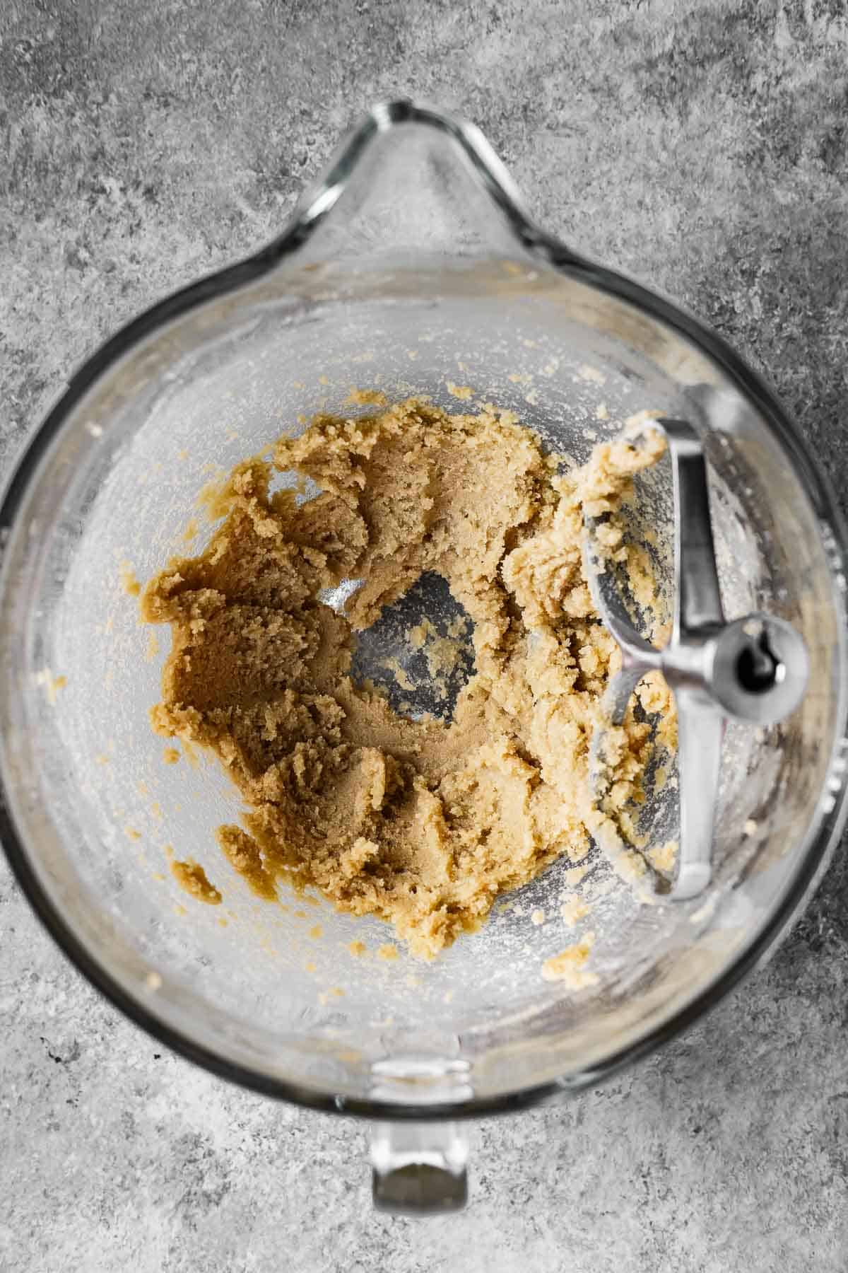 Butter and sugars creamed together in a mixing bowl.