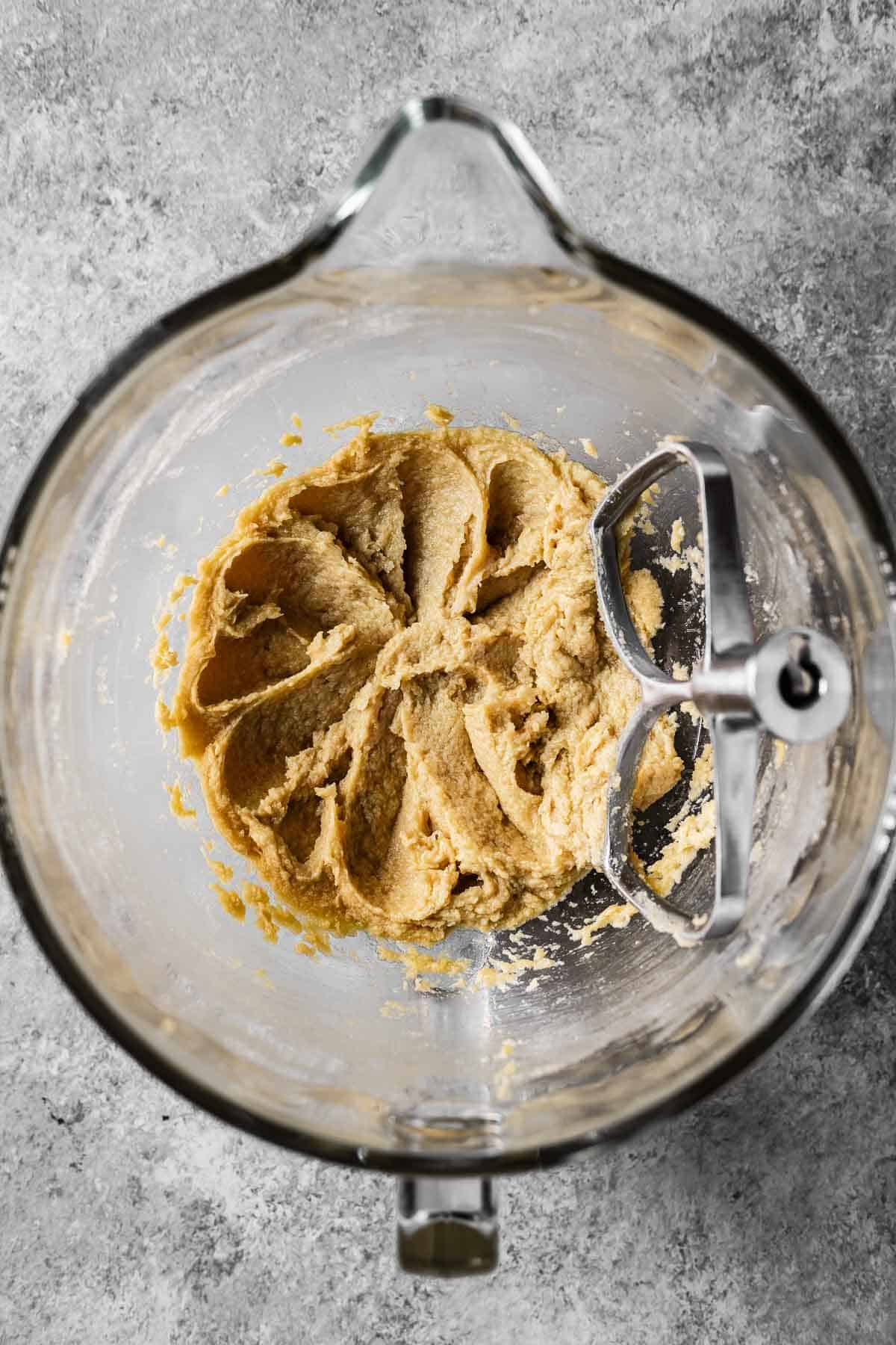 Wet ingredients beaten with butter and sugar in a mixing bowl.