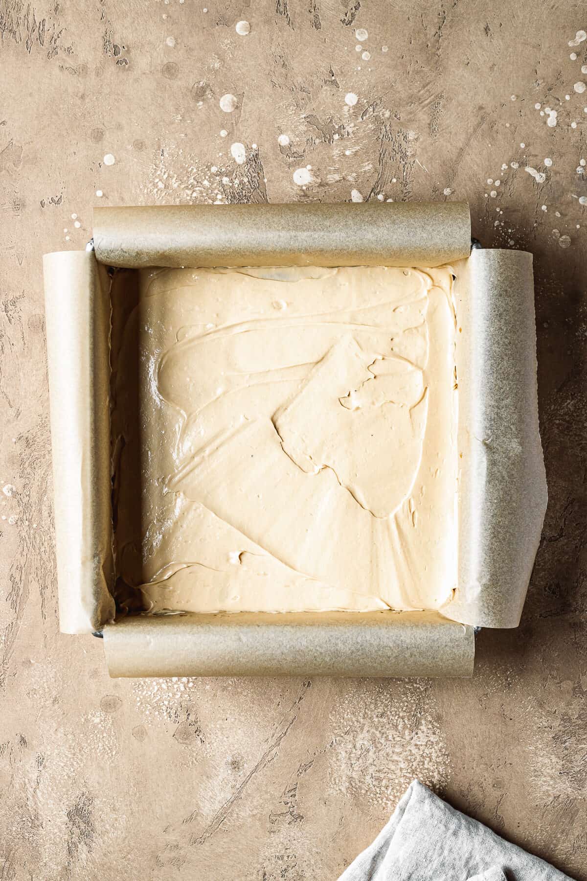 A smooth layer of dulce de leche filling in a square pan.