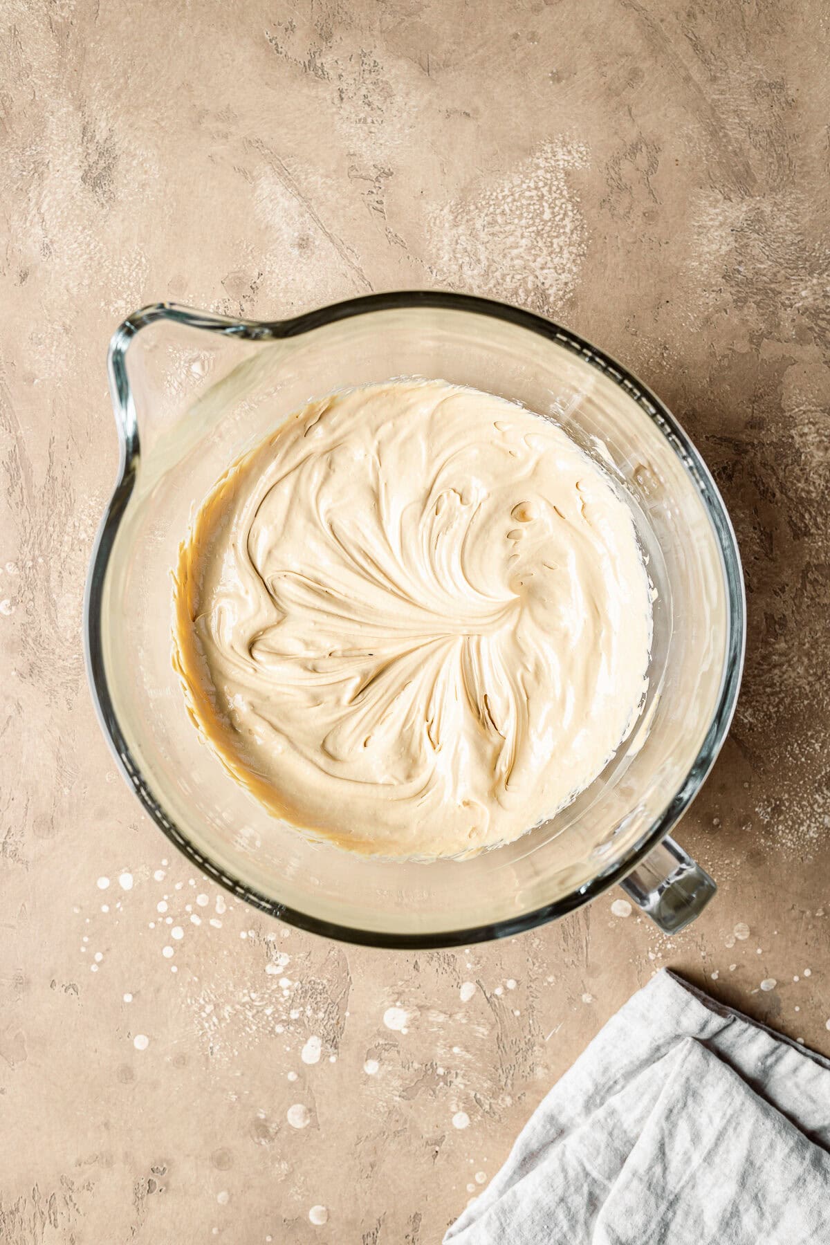 Smooth dulce de leche cream cheese mixture in a glass mixing bowl.