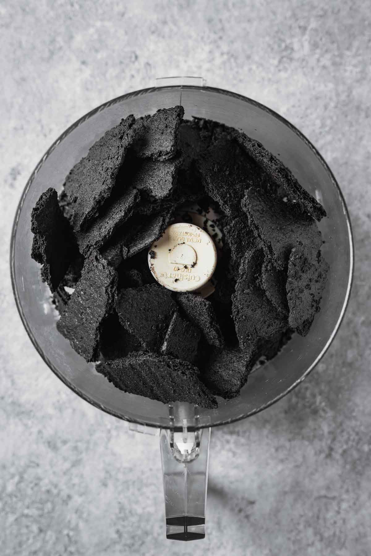 Chocolate wafer cookie chunks in a food processor.