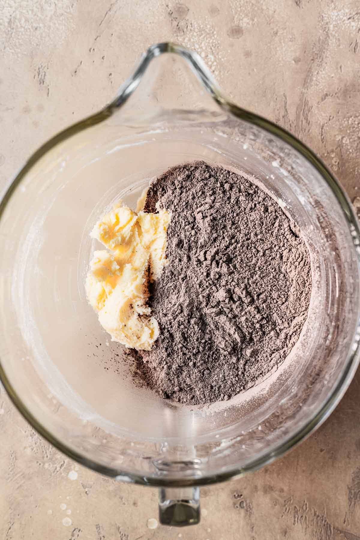 Dry ingredients with creamed butter and sugar in a mixing bowl.