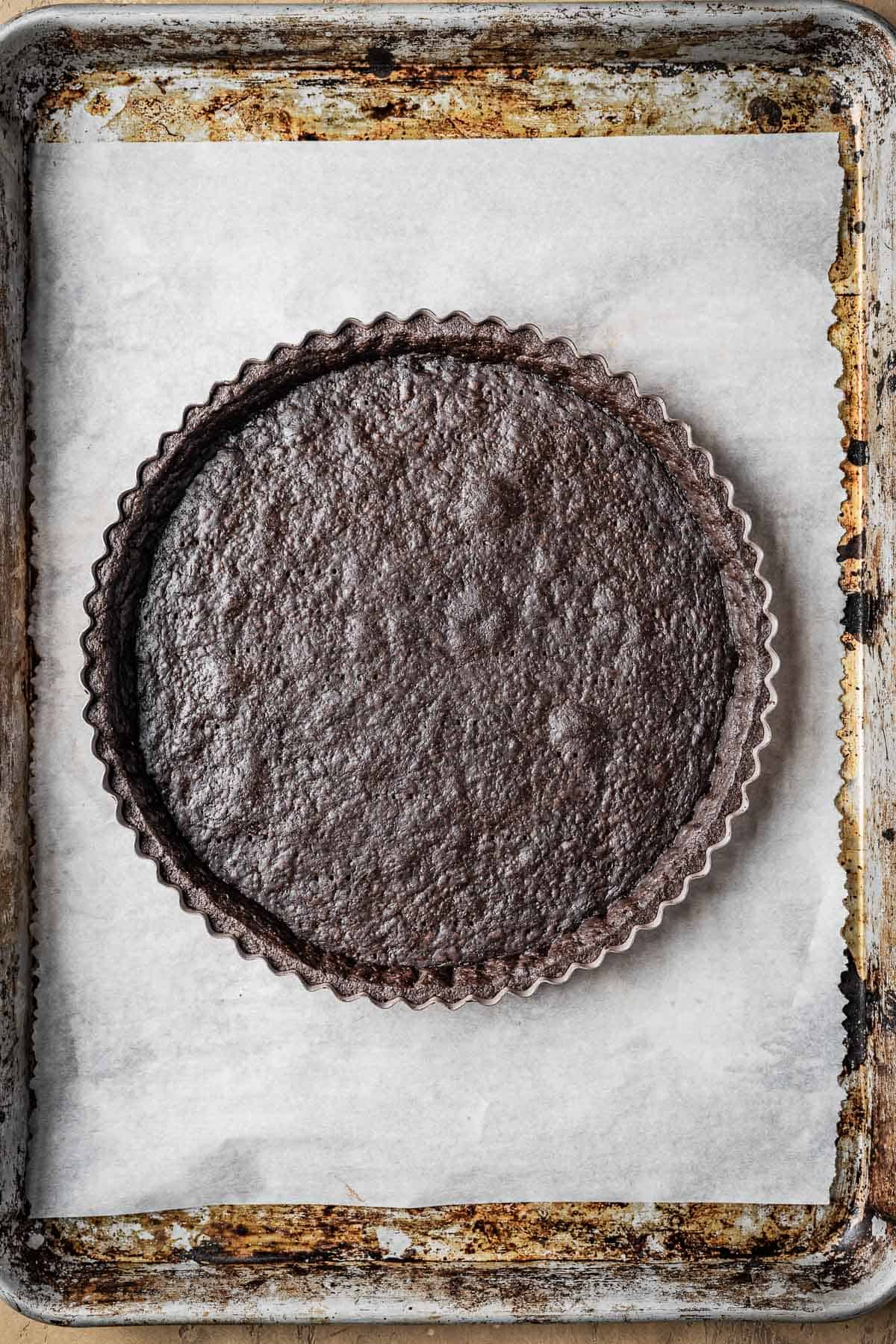 A baked and egg washed chocolate tart crust.