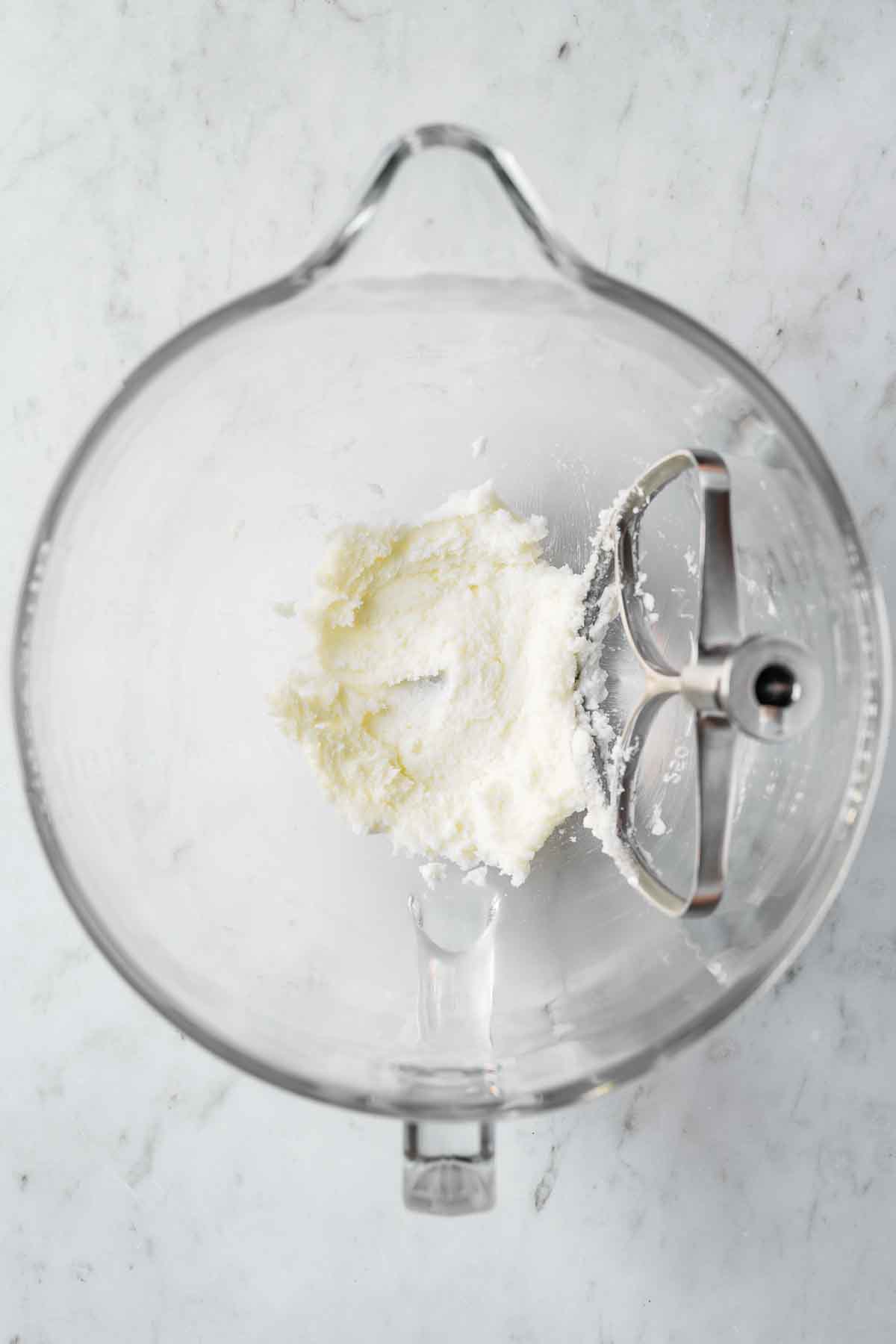 Creamed shortening and sugar in a glass mixing bowl.