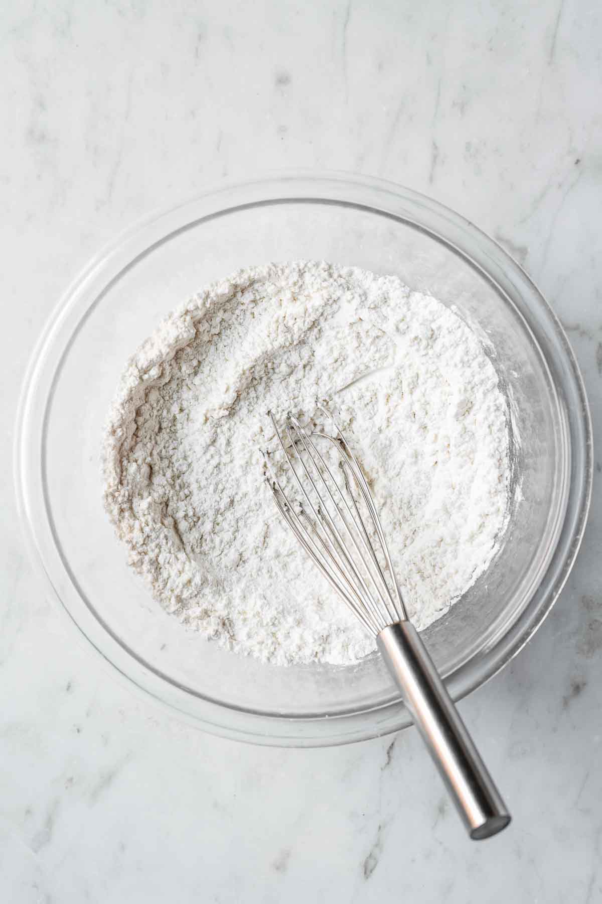 Whisked dry ingredients in a glass mixing bowl.