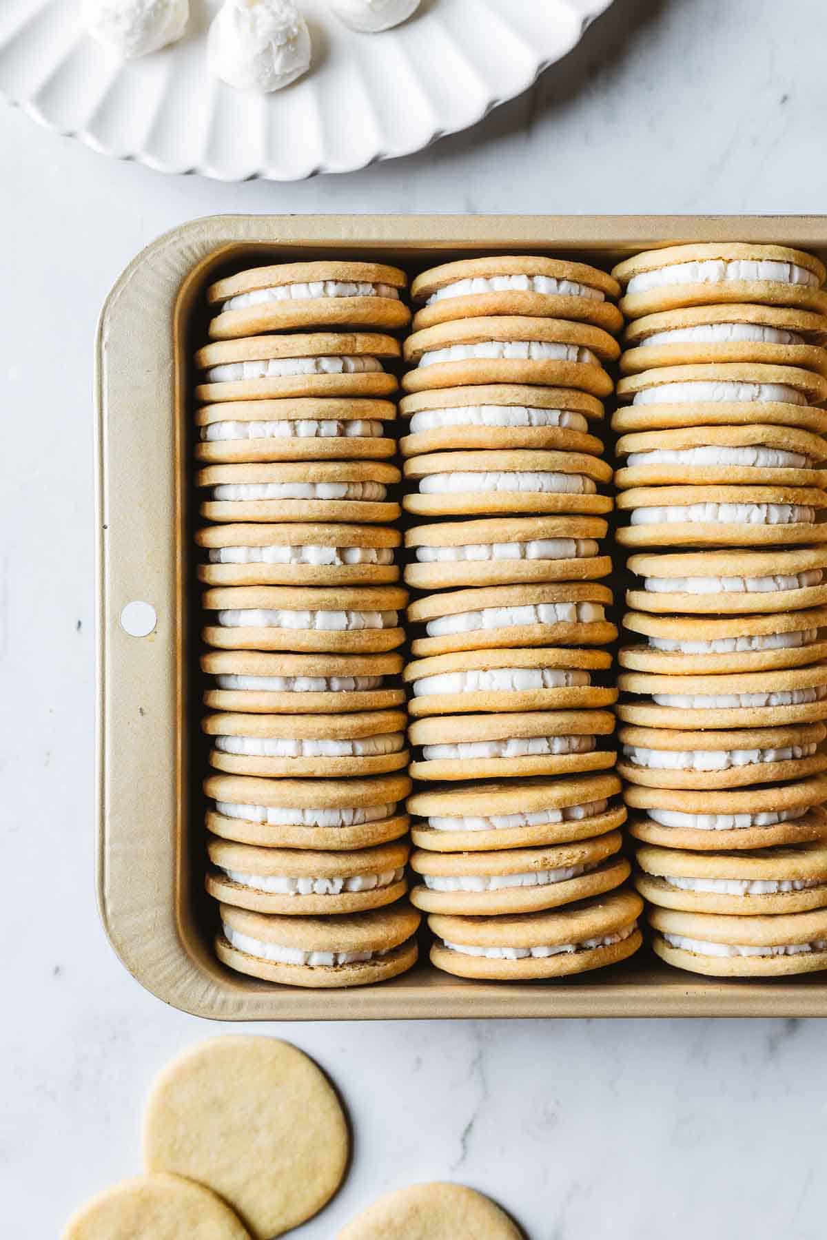 A gold pan with rows of Golden Oreos stuffed with vanilla creme filling.