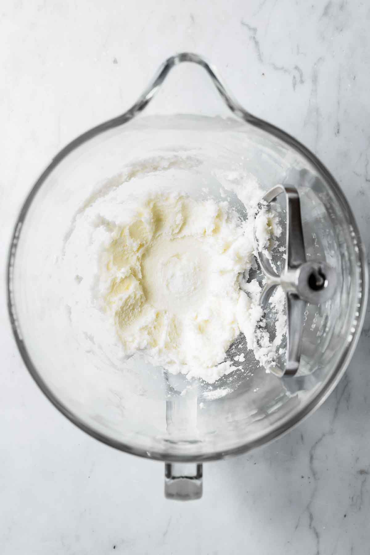Shortening and sugar mixed together in a glass bowl.