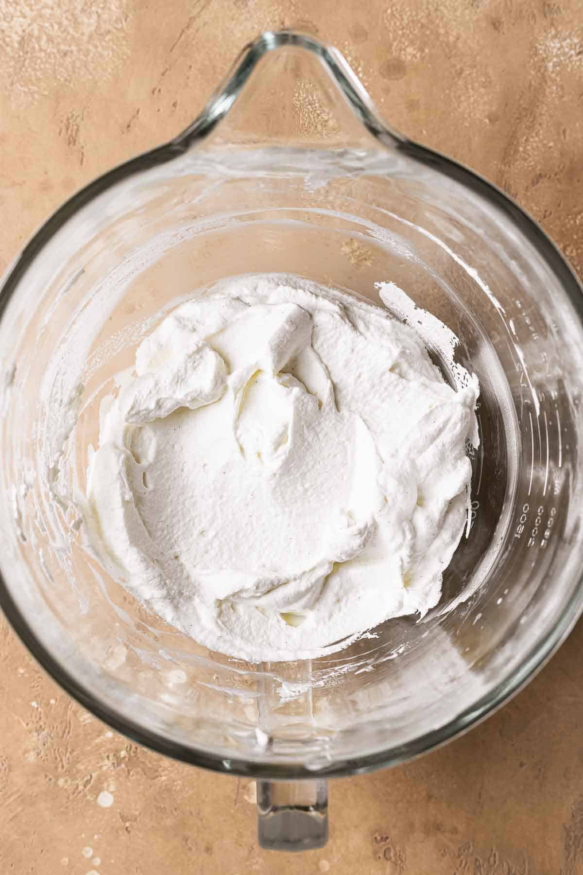 Sweetened whipped cream in a mixing bowl.