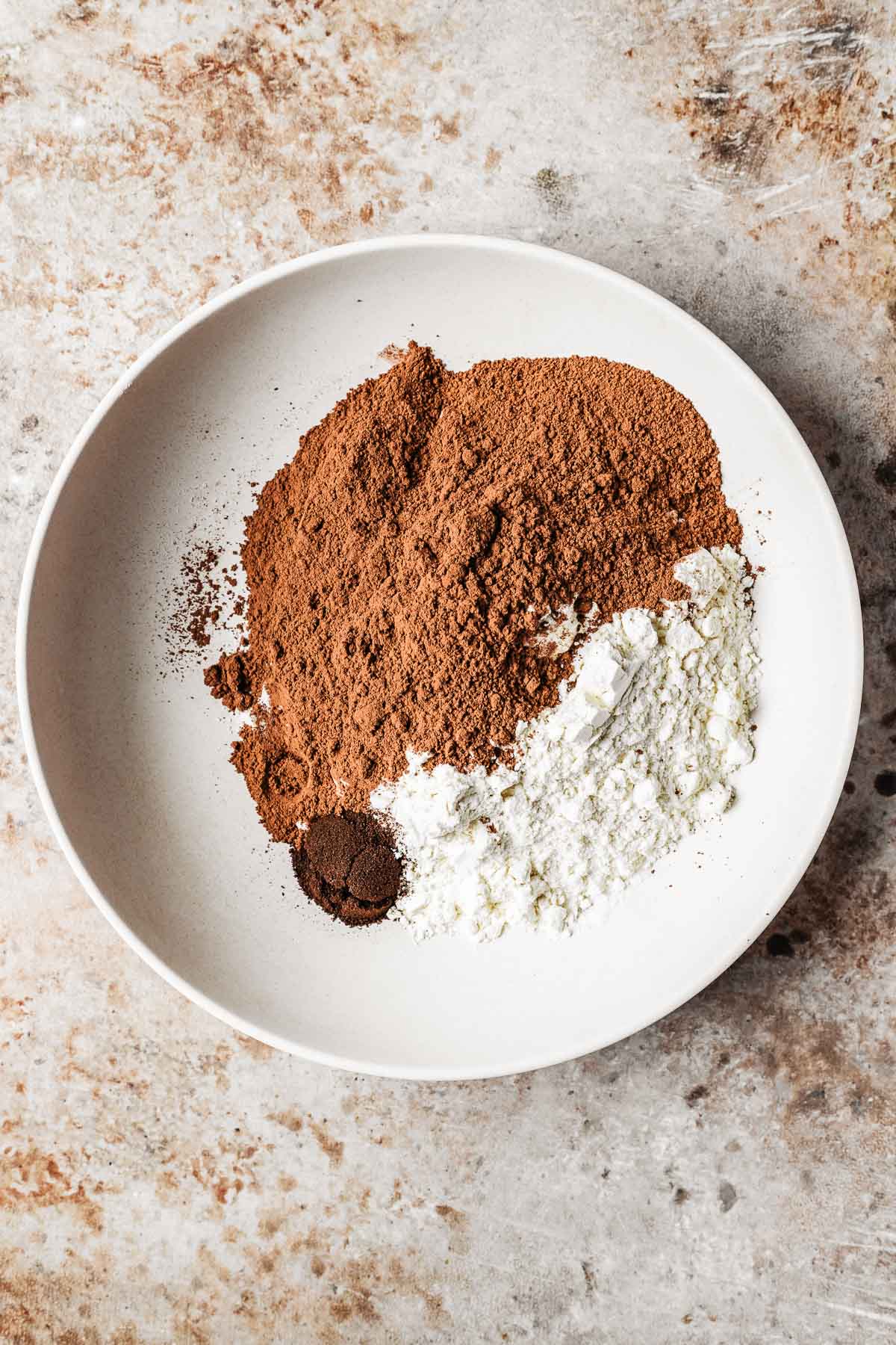 Dry ingredients measured out in a low bowl.