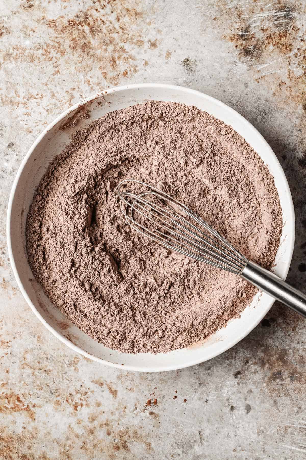 Dry ingredients mixed together with a whisk in a low bowl.