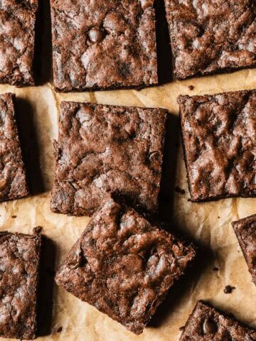 Double chocolate chip cookie bar squares on brown parchment paper.